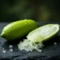 Caviar Cítrico Fresco Finger Lime cortado mostrando perlas verde esmeralda translúcidas sobre pizarra oscura cultivo Valencia