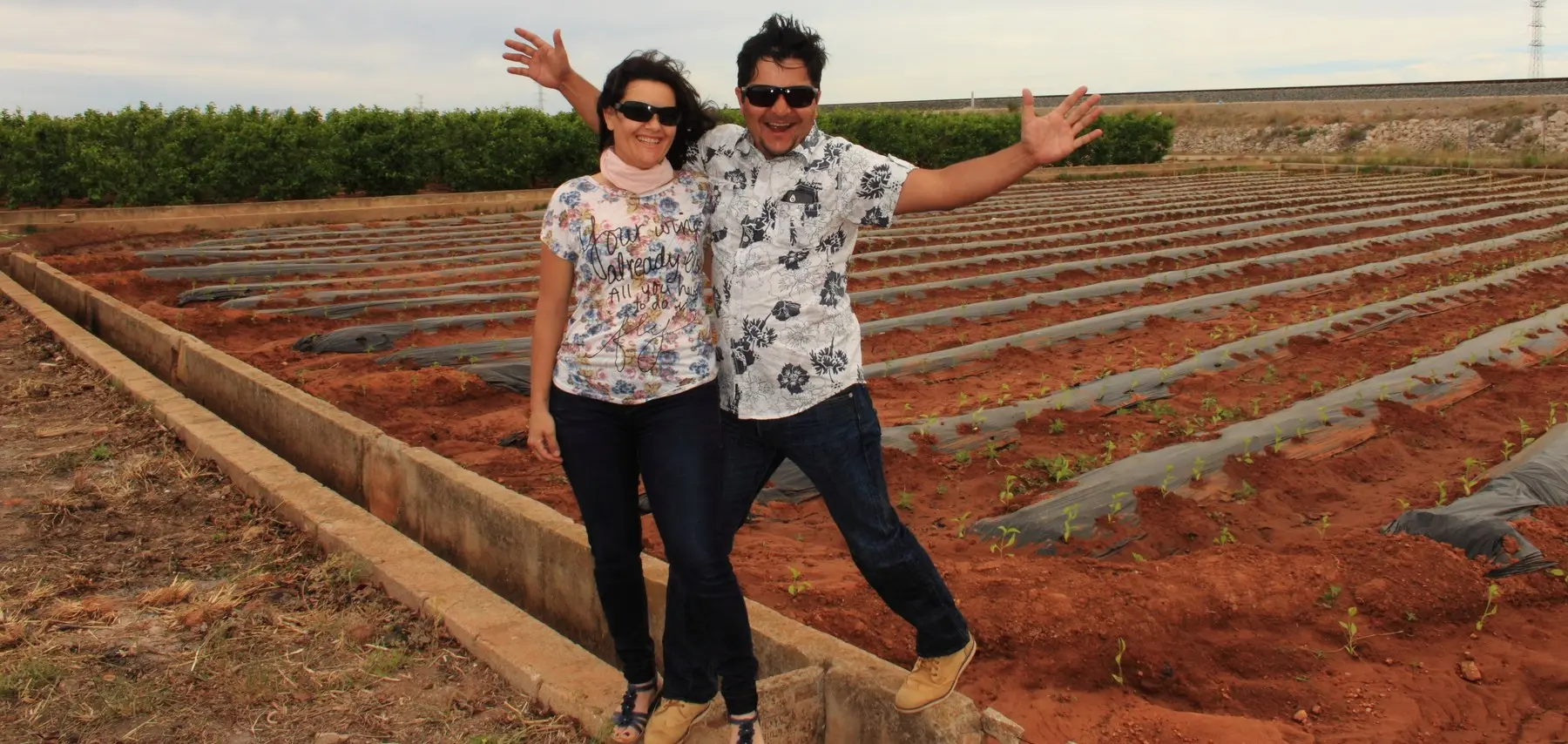 Carlos e Isabel sobre la acequia del primer campo, ya plantado de chiles mexicanos, en abril de 2014