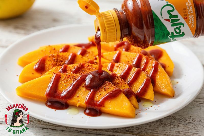 Salsa dulce picante mexicana vertida sobre rodajas de mango fresco